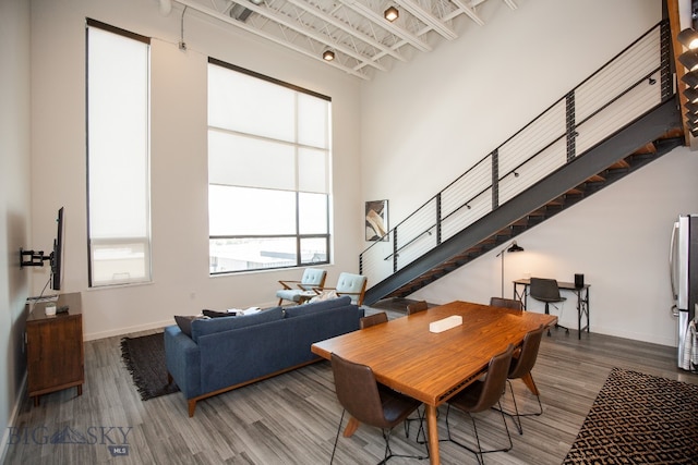 dining room with hardwood / wood-style floors and a high ceiling