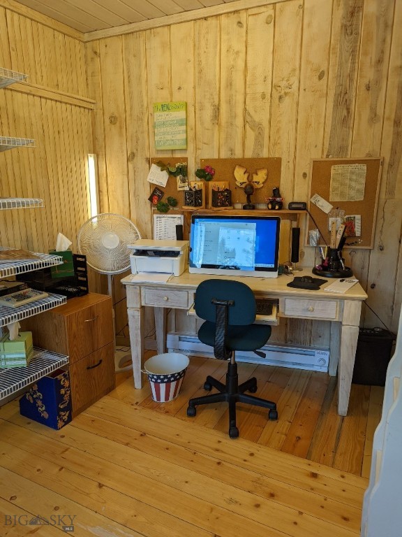 office space with light hardwood / wood-style flooring and wood walls