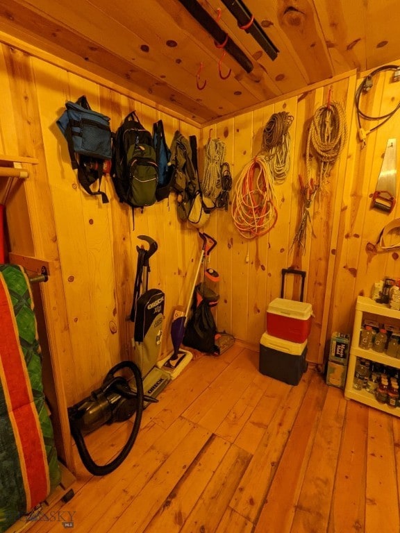 workout room with wood walls, hardwood / wood-style flooring, and wooden ceiling