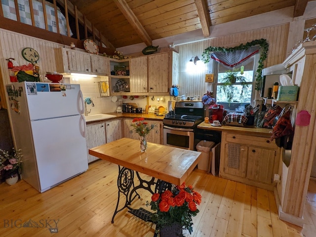 kitchen featuring lofted ceiling with beams, stainless steel stove, white refrigerator, light hardwood / wood-style flooring, and wooden ceiling