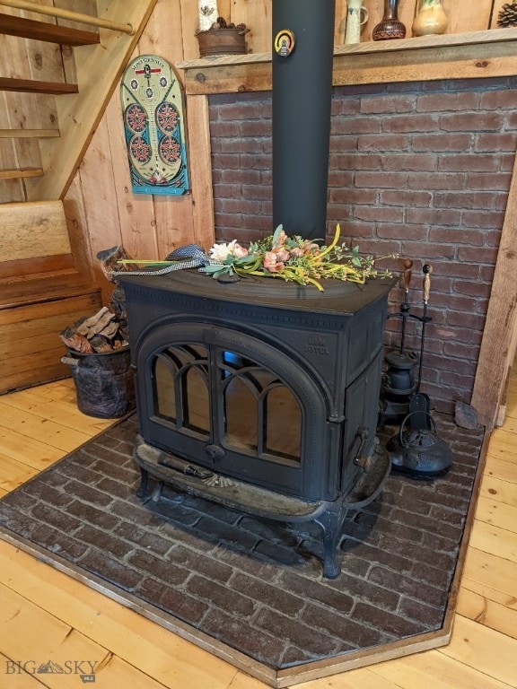 interior details with wooden walls, wood-type flooring, and a wood stove