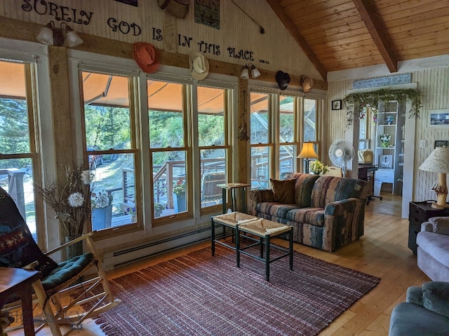 living room with a baseboard heating unit, plenty of natural light, and wood-type flooring