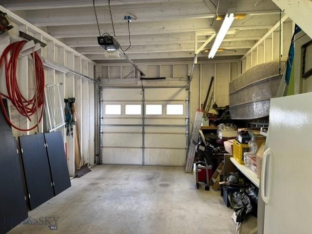 garage featuring freestanding refrigerator and a garage door opener