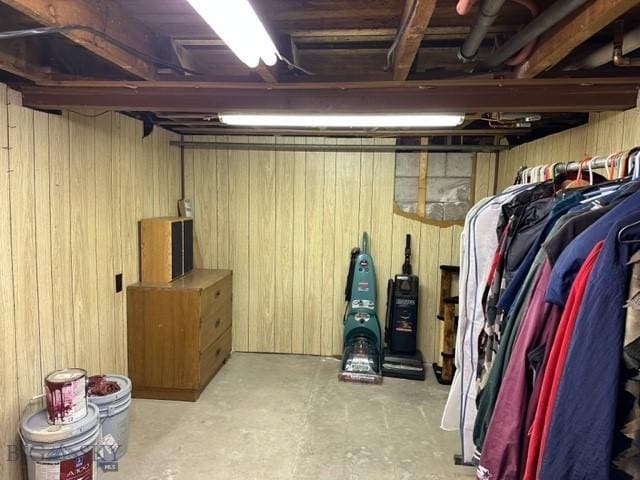 unfinished basement featuring wooden walls