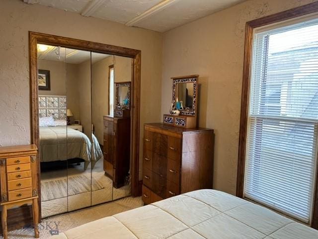 bedroom with a closet and a textured wall