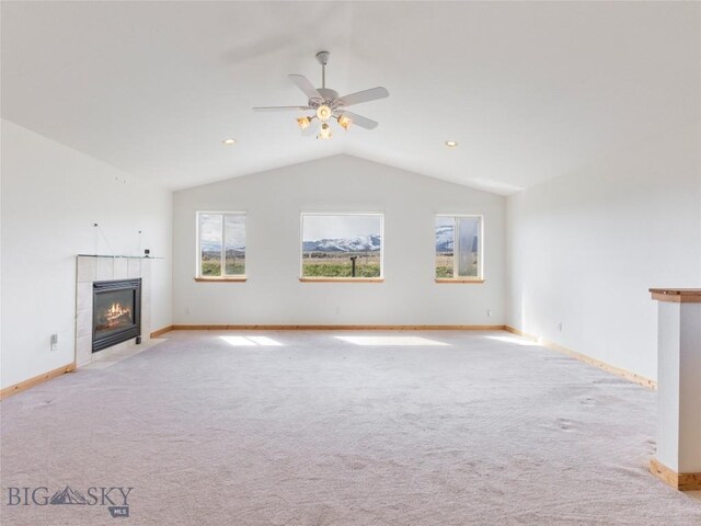 unfurnished living room with ceiling fan, light colored carpet, a fireplace, and vaulted ceiling