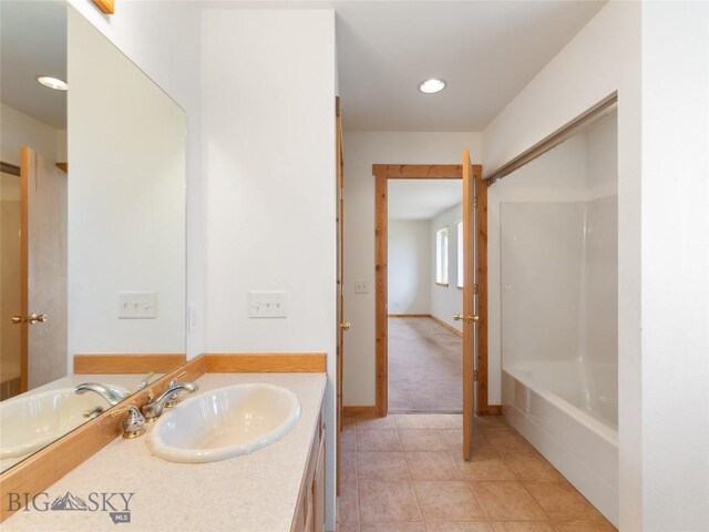 bathroom with vanity, a washtub, and tile patterned floors