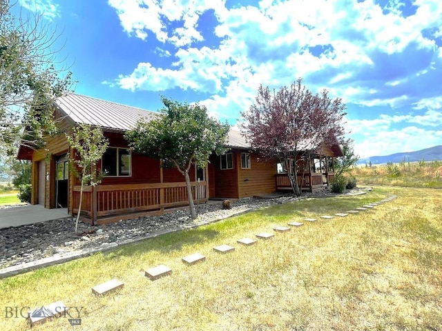 exterior space featuring a porch, a mountain view, and a front yard