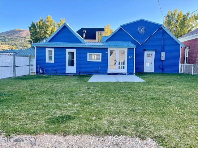 512 W Park, Anaconda, MT 59711 - rear view of house with a lawn, a patio area, a fenced backyard, and metal roof