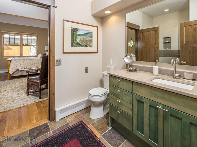 bathroom featuring vanity, baseboard heating, toilet, and hardwood / wood-style floors