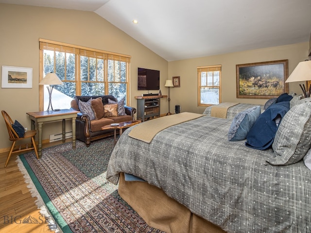 bedroom featuring hardwood / wood-style flooring, a baseboard heating unit, and lofted ceiling