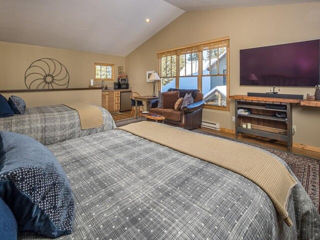 bedroom with refrigerator, lofted ceiling, and a baseboard heating unit