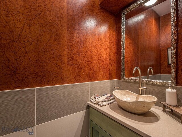 bathroom featuring vanity and tile walls