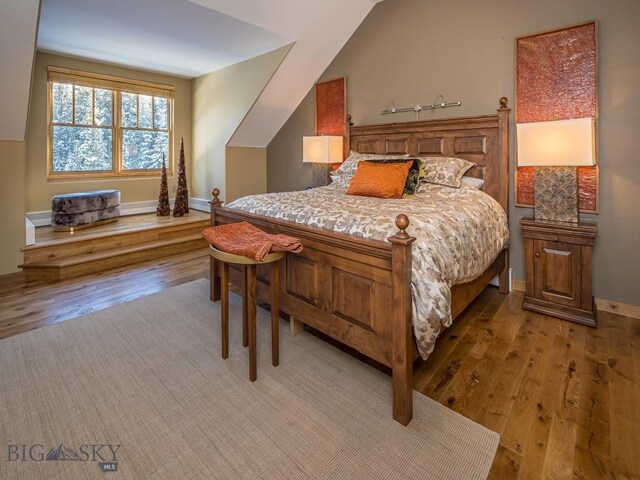 bedroom featuring vaulted ceiling and hardwood / wood-style floors