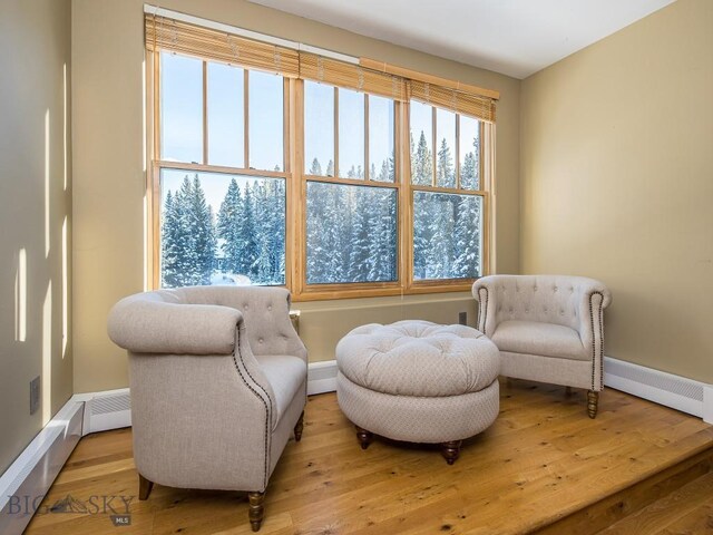 sitting room with light hardwood / wood-style flooring and a baseboard heating unit