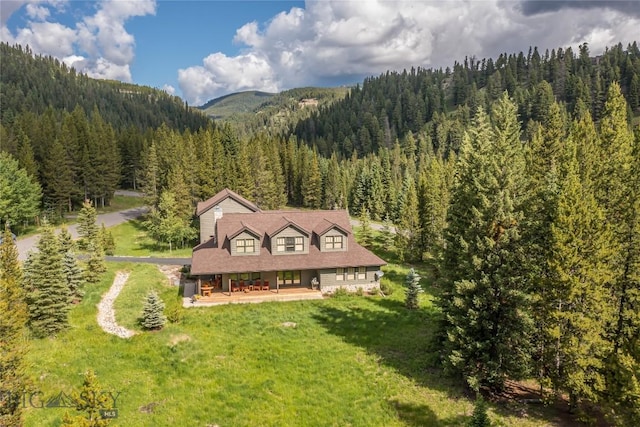 drone / aerial view with a mountain view and a forest view