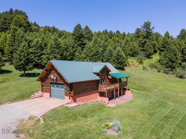 log cabin with a garage, a wooden deck, and a front yard