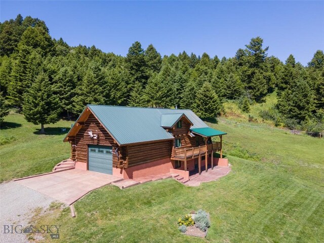 72 Sky Band Trl, Livingston, MT 59047 - view of front of property featuring log exterior, concrete driveway, a front lawn, and a view of trees