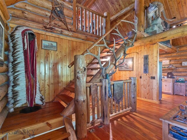 72 Sky Band Trl, Livingston, MT 59047 - staircase featuring log walls, hardwood / wood-style floors, wood walls, and wood ceiling with exposed beams