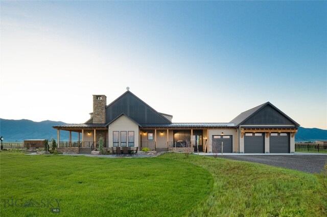 view of front facade with a garage, a yard, and covered porch