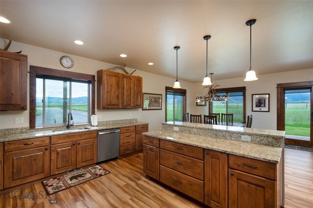 kitchen with light hardwood / wood-style floors, dishwasher, sink, and hanging light fixtures