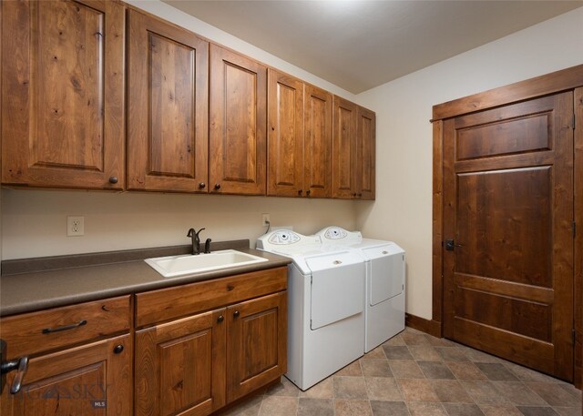 washroom with sink, washer and dryer, cabinets, and light tile floors