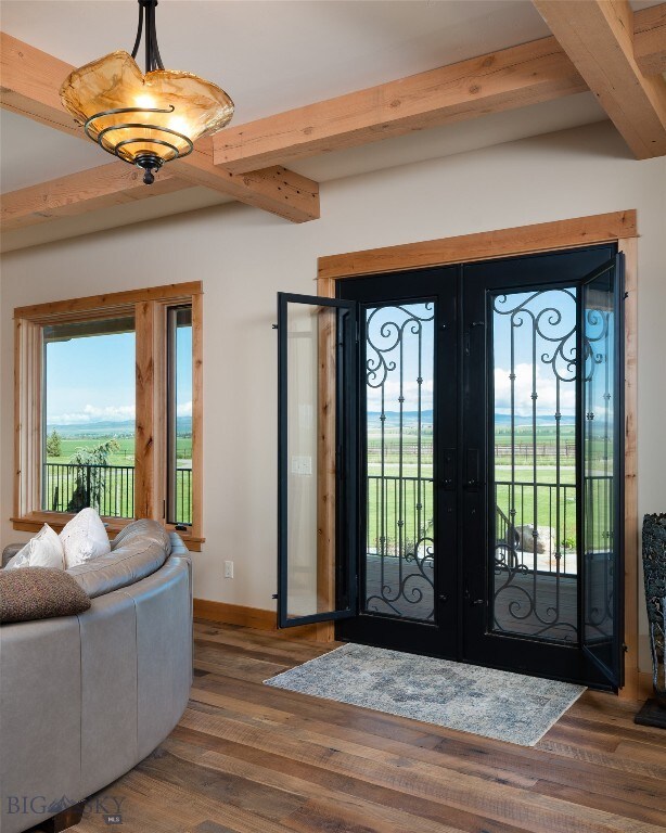 foyer entrance with hardwood / wood-style flooring, beam ceiling, and french doors