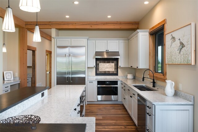 kitchen with pendant lighting, white cabinets, dark hardwood / wood-style floors, appliances with stainless steel finishes, and sink