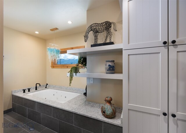 bathroom with tiled tub and tile flooring