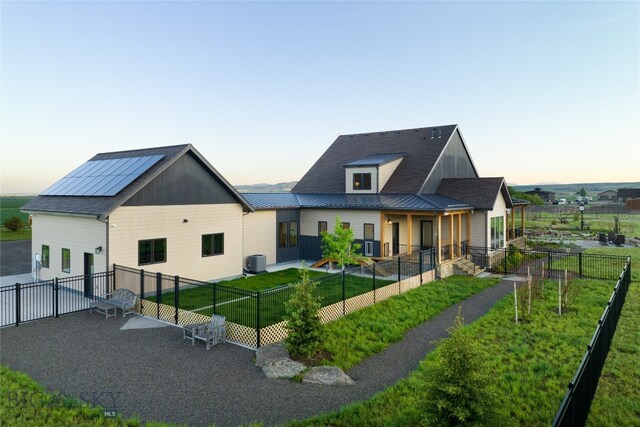 view of front of house with central AC unit and a lawn