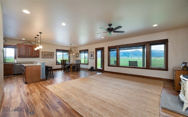 interior space featuring light hardwood / wood-style flooring and ceiling fan with notable chandelier