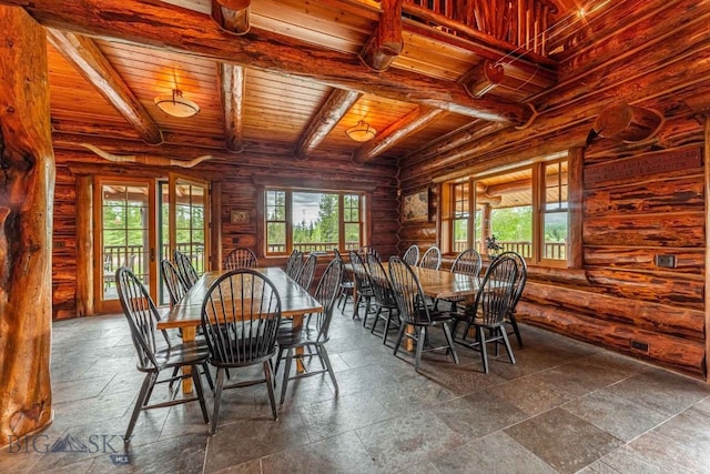 dining area with wood ceiling, rustic walls, tile floors, and beamed ceiling