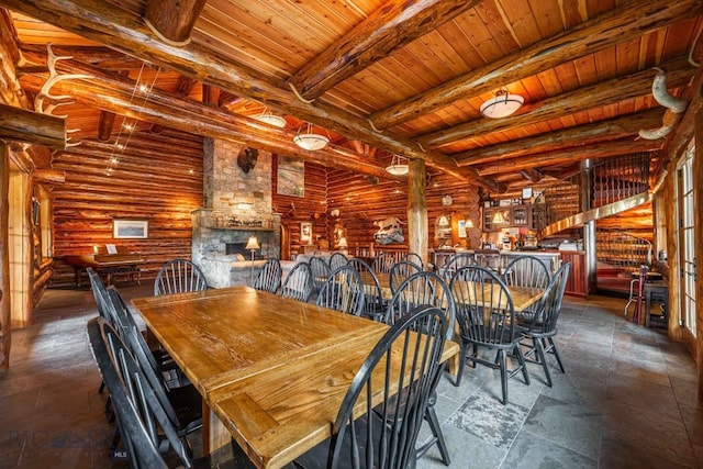 unfurnished dining area featuring beamed ceiling, log walls, tile flooring, a fireplace, and wooden ceiling