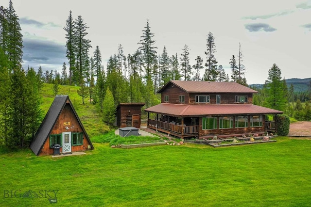 rear view of property with an outdoor structure and a lawn