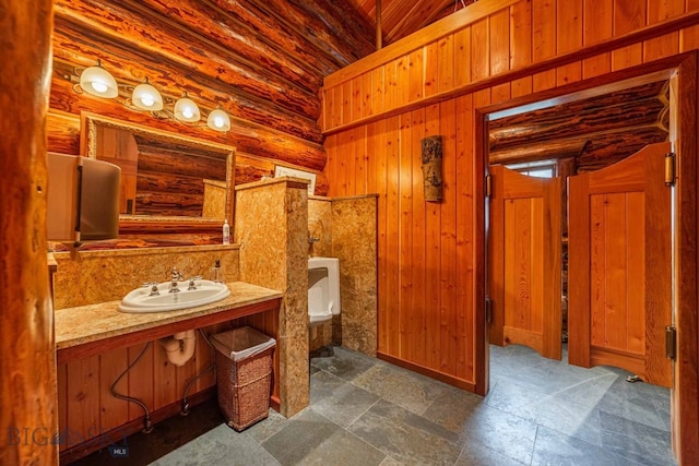 bathroom with tile flooring, log walls, wood ceiling, wood walls, and vanity