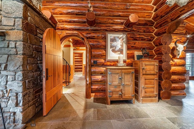 hallway featuring lofted ceiling, log walls, and tile flooring