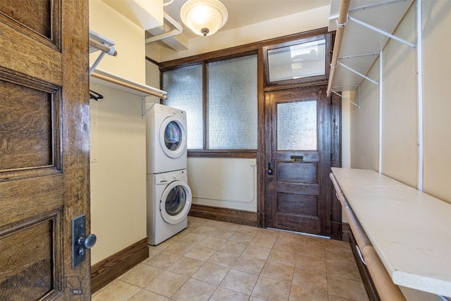 washroom featuring light tile floors and stacked washer / drying machine