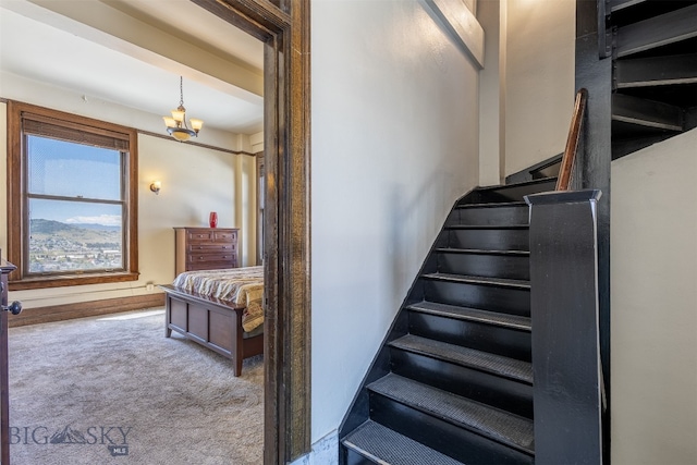 stairs featuring carpet flooring and an inviting chandelier