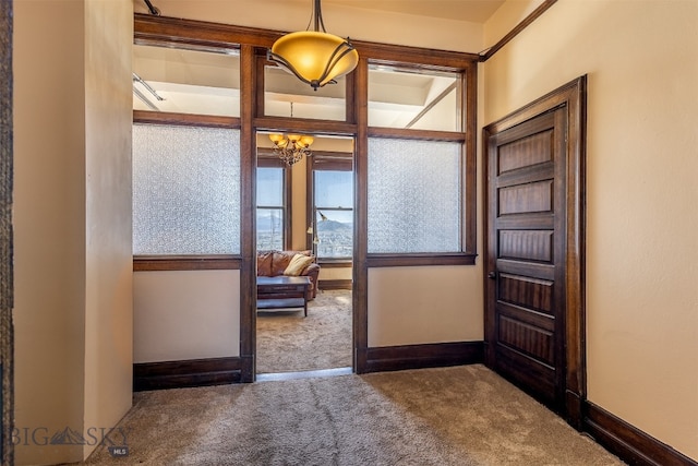 hallway featuring a chandelier and carpet floors