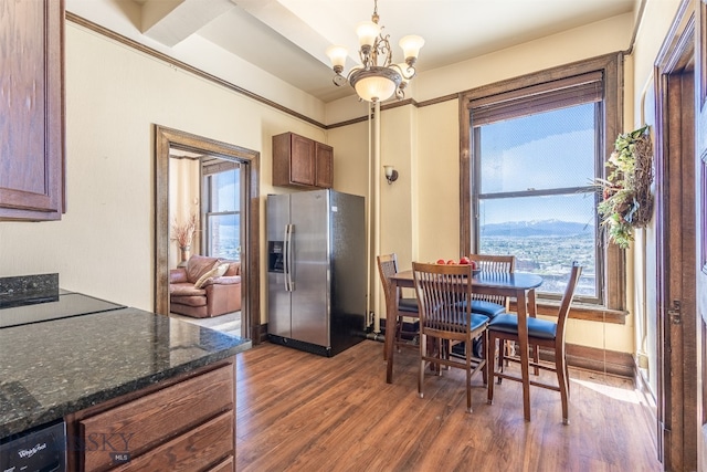 dining area with dark hardwood / wood-style floors, a mountain view, and a chandelier