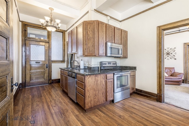 kitchen featuring appliances with stainless steel finishes, a chandelier, sink, and dark hardwood / wood-style floors