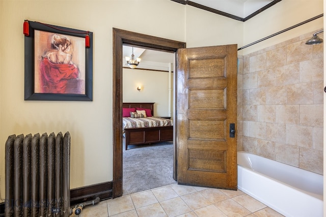 bathroom featuring tile floors, radiator heating unit, tiled shower / bath, and a chandelier