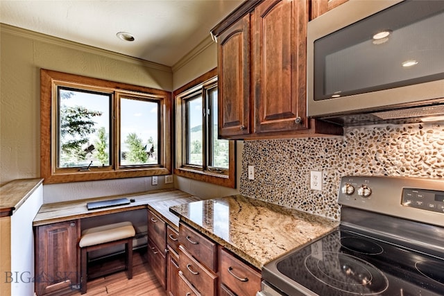 kitchen with appliances with stainless steel finishes, backsplash, crown molding, light hardwood / wood-style flooring, and light stone countertops