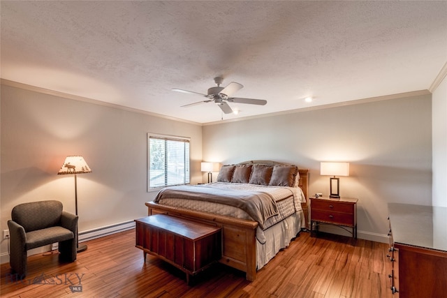 bedroom with wood-type flooring, ceiling fan, crown molding, and a baseboard heating unit