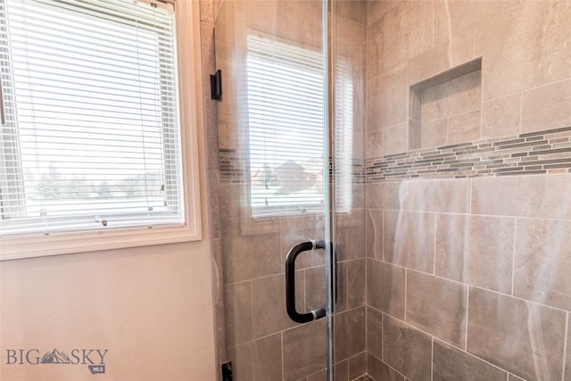 bathroom with a shower with door