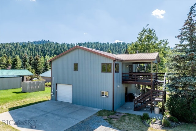 view of front of house featuring a front lawn, a wooden deck, an outdoor structure, and a garage