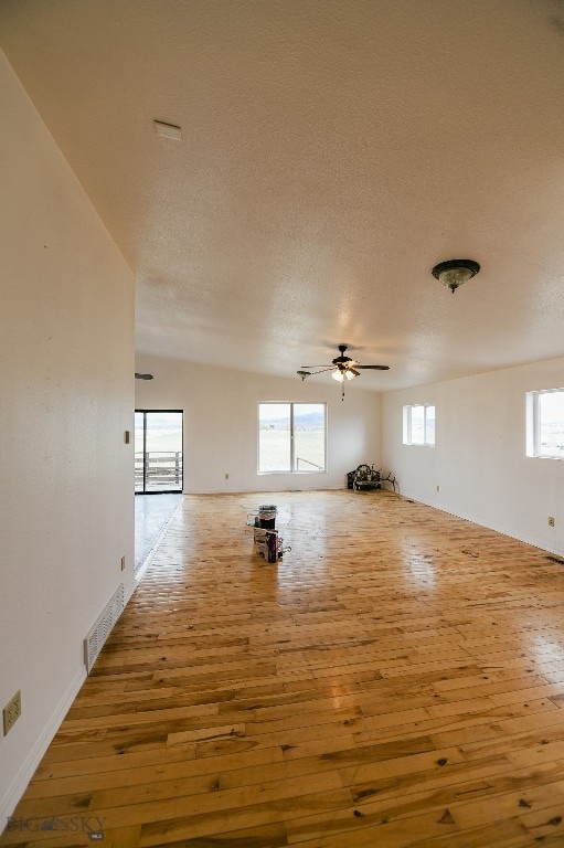 empty room featuring ceiling fan, hardwood / wood-style flooring, and a textured ceiling