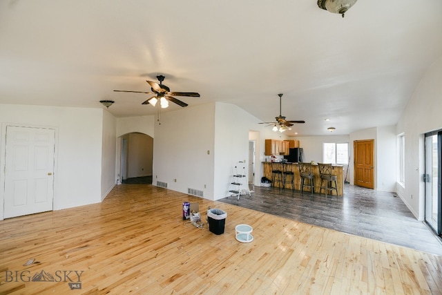 unfurnished living room featuring light hardwood / wood-style floors, ceiling fan, and lofted ceiling