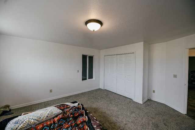 unfurnished bedroom with a closet and dark colored carpet