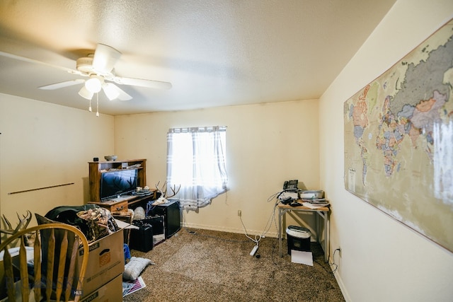 carpeted home office with a textured ceiling and ceiling fan